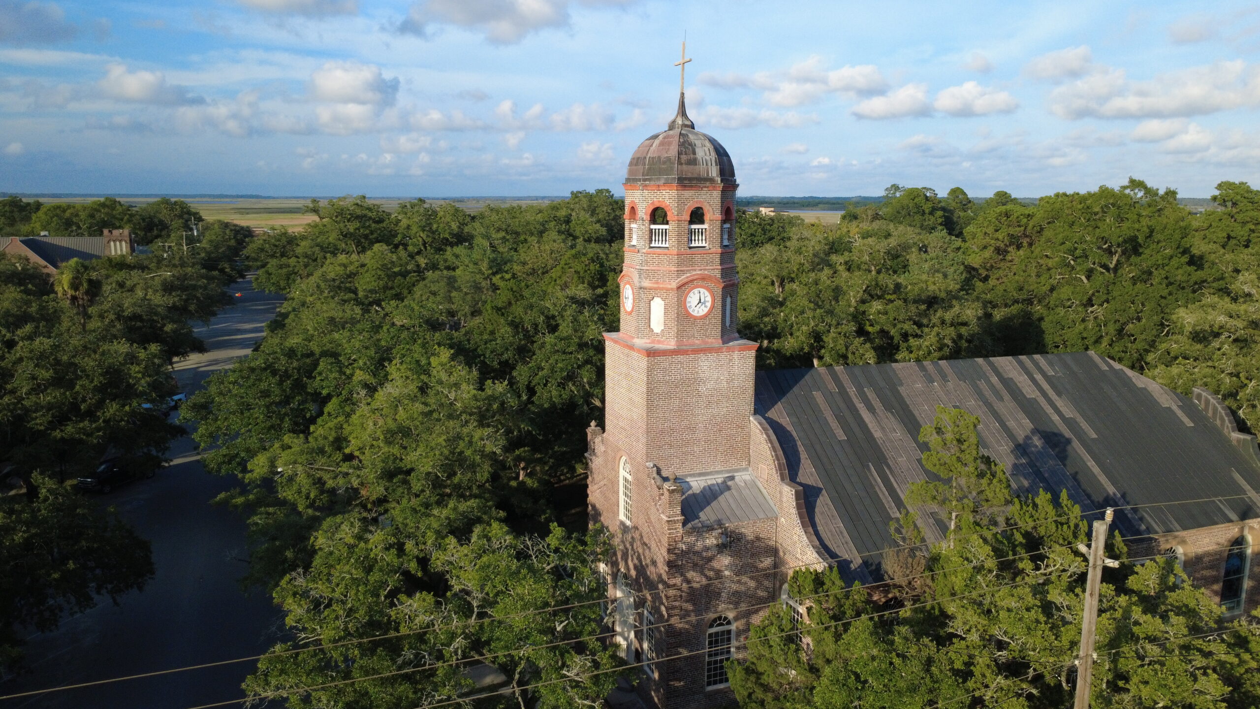 Aerial view of a historic red-brick church with clock tower in South Carolina’s Lowcountry